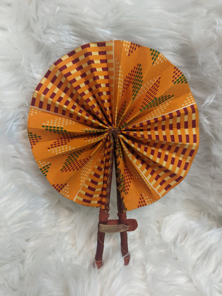 Colorful, cotton fabric and foldable mini fans. Handle made of leather with leather thong to hold together.