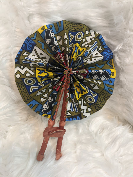 Colorful, cotton fabric and foldable mini fans. Handle made of leather with leather thong to hold together.