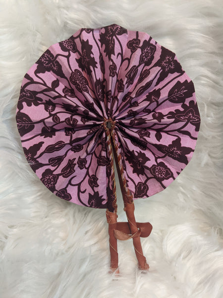 Colorful, cotton fabric and foldable mini fans. Handle made of leather with leather thong to hold together.