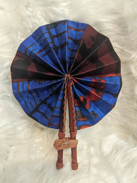 Colorful, cotton fabric and foldable mini fans. Handle made of leather with leather thong to hold together.