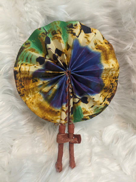 Colorful, cotton fabric and foldable mini fans. Handle made of leather with leather thong to hold together.