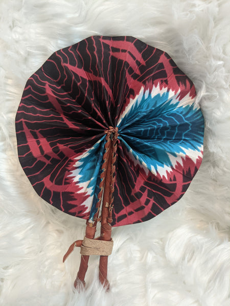 Colorful, cotton fabric and foldable mini fans. Handle made of leather with leather thong to hold together.