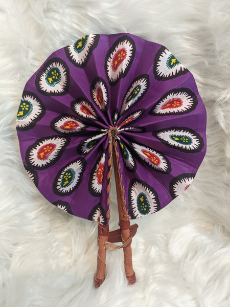 Colorful, cotton fabric and foldable mini fans. Handle made of leather with leather thong to hold together.