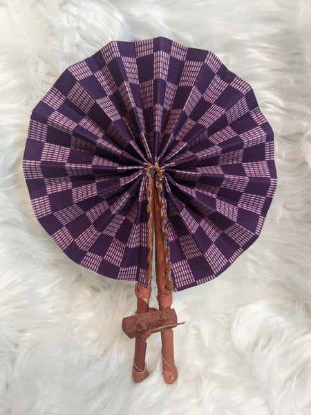 Colorful, cotton fabric and foldable mini fans. Handle made of leather with leather thong to hold together.