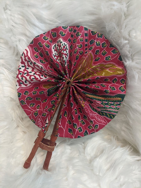 Colorful, cotton fabric and foldable mini fans. Handle made of leather with leather thong to hold together.